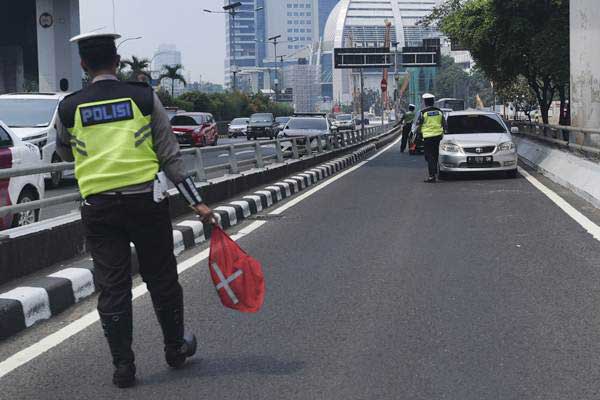 Ilustrasi petugas Ditlantas Polda Metro Jaya memberhentikan mobil berpelat nomor genap yang memasuki Jalan Gatot Soebroto, Jakarta, Rabu (1/8/2018). - ANTARA/Hafidz Mubarak A