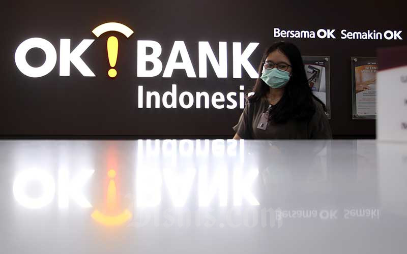 Karyawan berada di depan logo PT Bank Oke Indonesia Tbk. (DNAR) di Jakarta, Jumat (8/5/2020). Bisnis - Abdullah Azzam