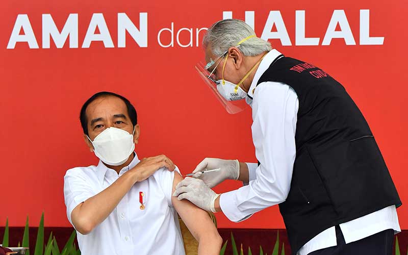 Presiden Joko Widodo bersiap disuntik dosis pertama vaksin Covid-19 produksi Sinovac oleh vaksinator Wakil Ketua Dokter Kepresidenan Abdul Mutalib (kanan) di beranda Istana Merdeka, Jakarta, Rabu (13/1/2021). Penyuntikan perdana vaksin Covid-19 ke Presiden Joko Widodo tersebut menandai dimulainya program vaksinasi di Indonesia. ANTARA FOTO/HO - Setpres/Agus Suparto