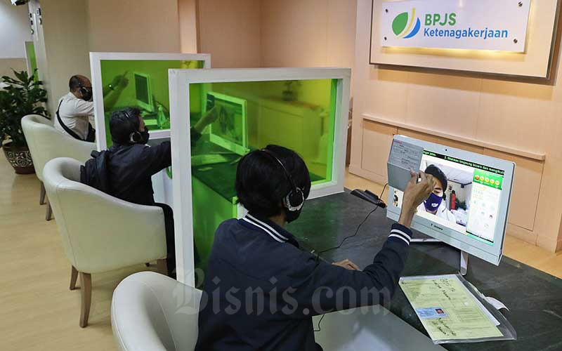 Peserta BP Jamsostek berkomunikasi dengan petugas pelayanan saat mengurus klaim melalui layar monitor dan tanpa kontak langsung di Kantor Cabang BP Jamsostek di Menara Jamsostek, Jakarta, Jumat (10/7/2020). Bisnis - Eusebio Chrysnamurti