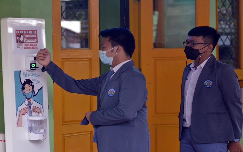Pelajar mengecek suhu badannya sebelum memasuki ruang kelas di SMA Negeri 2 Bandar Lampung, Lampung, Senin (13/9/2021).ANTARA FOTO -  Ardiansyah