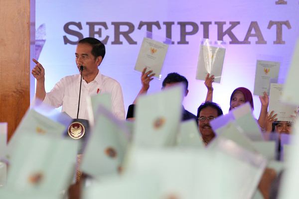 Warga menunjukkan sertifikat yang sudah diterima kepada Presiden Joko Widodo di Pendopo Sasana Adhi Praja, Blitar, Jawa Timur, Rabu (3/1/2019). - ANTARA/Irfan Anshori