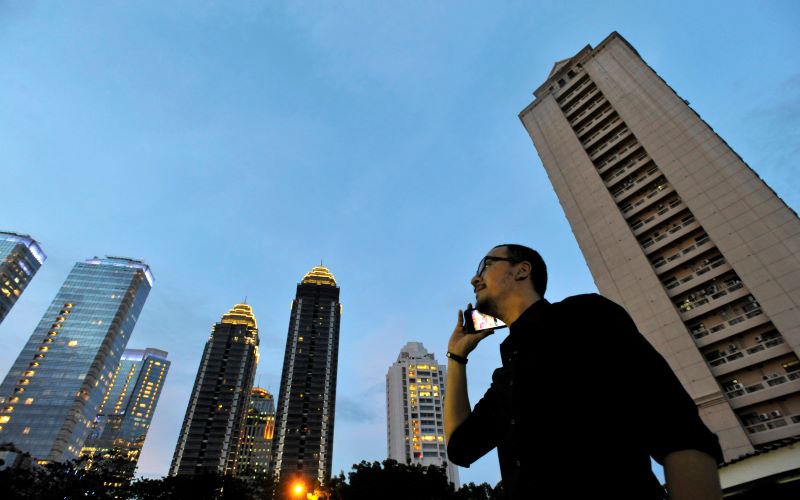Seorag pria menelepon dengan latar belakang gedung perkantoran di kawasan bisnis terpadu Sudirman Central Business District (SCBD), Jakarta.  - Antara Foto/Andika Wahyu.