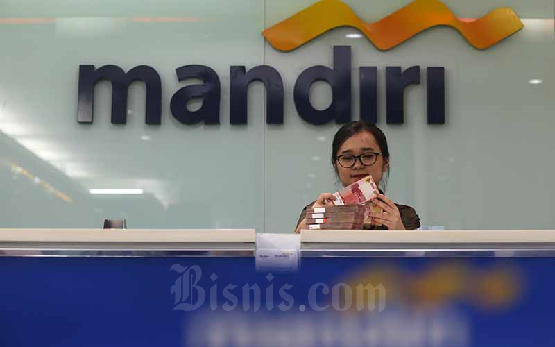 Karyawati menghitung uang pecahan uang Rp100.000 di salah satu kantor cabang milik PT Bank Mandiri Tbk di Jakarta, Rabu (12/6/2019). Bisnis - Nurul Hidayat