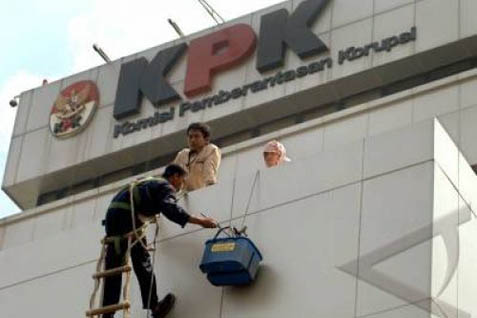 Seorang petugas kebersihan sedang membersihkan dinding gedung Komisi Pemberantasan Korupsi (KPK). - Ilustrasi
