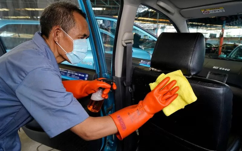 Ilustrasi pengemudi tengah membersihkan kabin mobil Bluebird.  - Bluebird/Antara