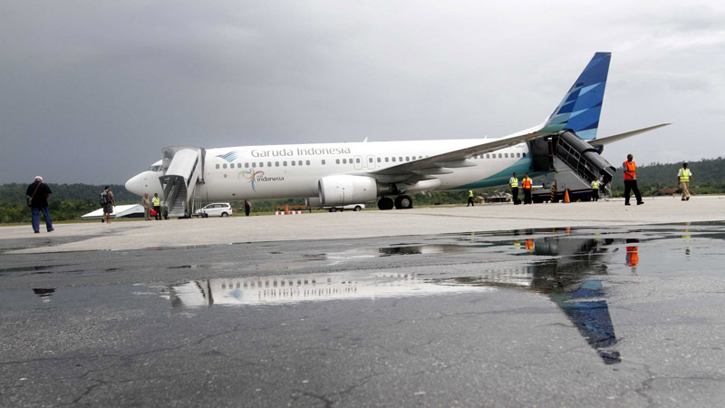 Penumpang bersiap menaiki pesawat maskapai penerbangan Garuda Indonesia di Bandara Frans Kaisiepo Biak, Papua, Selasa (29/10/2013).  - Bisnis/Dwi Prasetya
