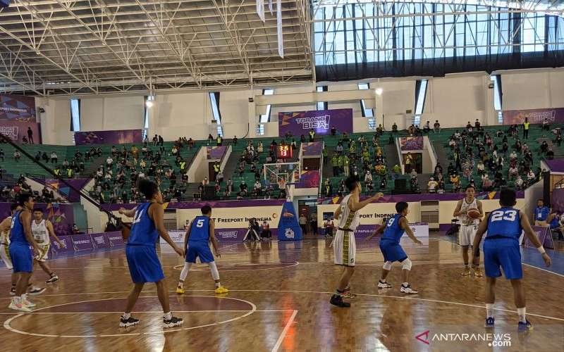 Tim bola basket putra Jawa Timur (seragam putih) berlaga menghadapi Jawa Tengah dalam laga perebutan tempat ketiga PON XX Papua di Mimika Sport Complex, Mimika, Sabtu (9/10/2021). Jawa Timur menang 63-55 pada pertandingan itu dan berhak atas medali perunggu. ANTARA - Michael Siahaan