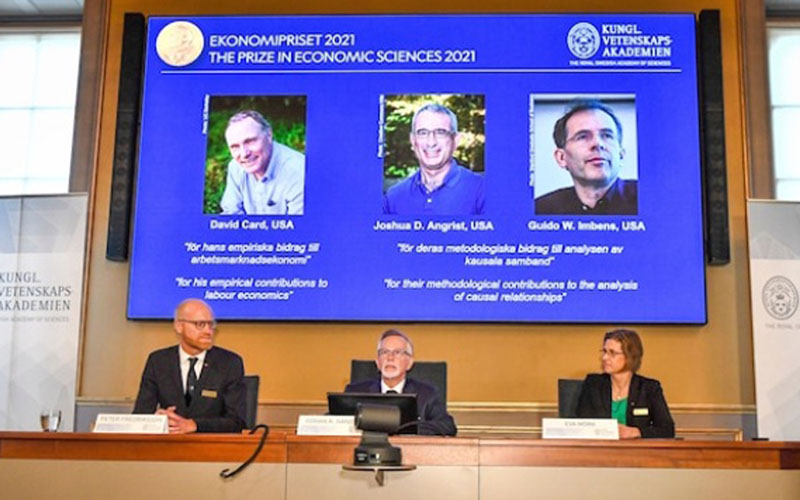 Suasana pengumuman pemenang Hadiah Nobel DEkonomi 2021. Di latar belakang tampak gambar ketiga pemenang yakni David Card, Joshua D. Angrist, dan Guido W. Imbens. - NobelPrize.org