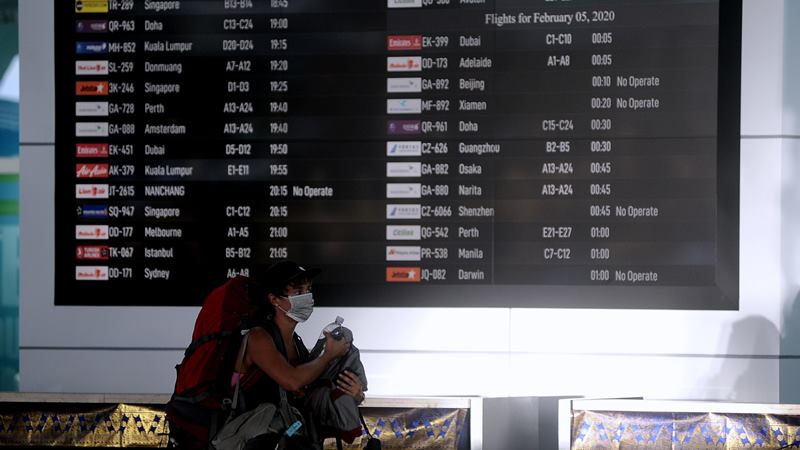 Penumpang melintas di dekat layar informasi penerbangan di Terminal Keberangkatan Internasional Bandara Internasional I Gusti Ngurah Rai, Bali, Selasa (4/2/2020). -  ANTARA / Fikri Yusuf