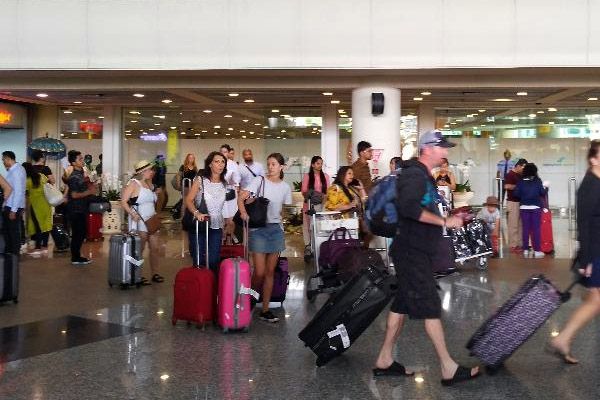 Sejumlah wisatawan keluar dari pintu kedatangan terminal internasional Bandara Ngurah Rai, Minggu (26/11/2017) - Bisnis / Ema Sukarelawanto