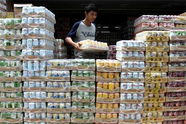 Pekerja menyusun aneka jenis minuman kaleng di salah satu grosir penjual makanan dan minuman kemasan di Pekanbaru, Riau, Senin (12/6). - Antara/Rony Muharrman