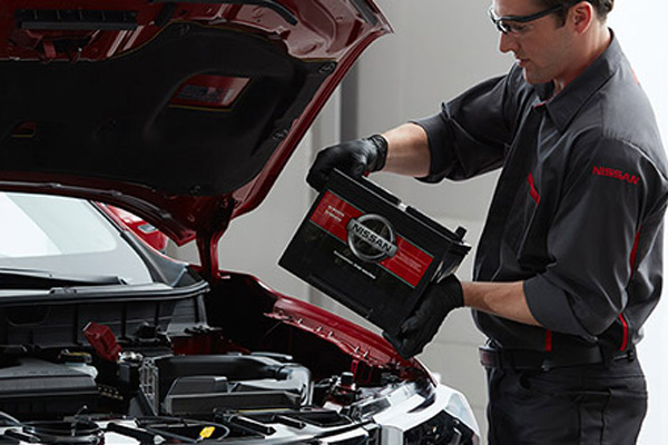 Teknisi memasang baterai pada mobil Nissan. /nissanservicenow.com