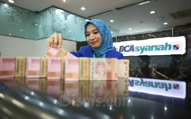 Karyawan menghitung uang rupiah di kantor cabang Bank BCA Syariah di Jakarta, Selasa (7/1/2020). Bisnis - Abdullah Azzam