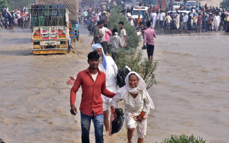 Korban banjir berjalan melintasi jalan raya nasional yang banjir setelah sungai Kosi meluap menyusul hujan lebat di dekat Rampur di negara bagian Uttar Pradesh India pada 20 Oktober 2021. Saat ini jumlah korban tewas akibat banjir dan tanah longsor di India dan Nepal melewati angka 100. - Istimewa