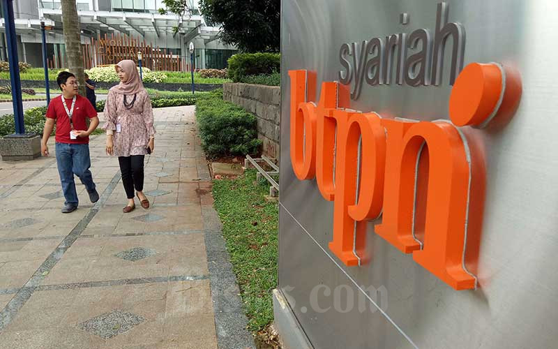 Pejalan kaki berjalan melewati logo PT Bank Tabungan Pensiunan Nasional Syariah Tbk atau BTPN Syariah di Jakarta, Senin (13/1/2020). Bisnis - Dedi Gunawan\n