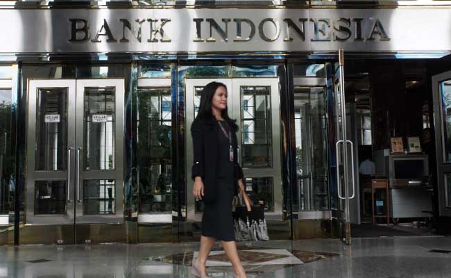 Karyawan melintas di dekat logo Bank Indonesia di Jakarta, Senin (3/2 - 2020).