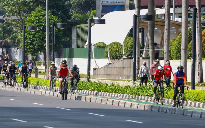 Warga berolahraga di Jalan Jenderal Sudirman, Jakarta, Minggu (3/10/2021).  - Antara Foto/Rivan Awal Lingga