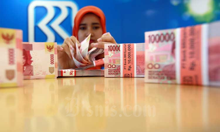 Karyawan menanta uang rupiah di kantor cabang Bank BRI syariah, Senin (3/7/2017). Bisnis - Abdullah Azzam