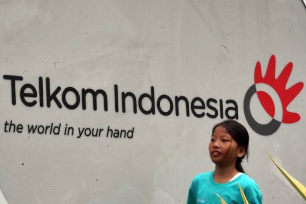 Pejalan kaki berjalan melewati logo Telkom di Jakarta, Senin (27/11/2017).  - JIBI/Dedi Gunawan
