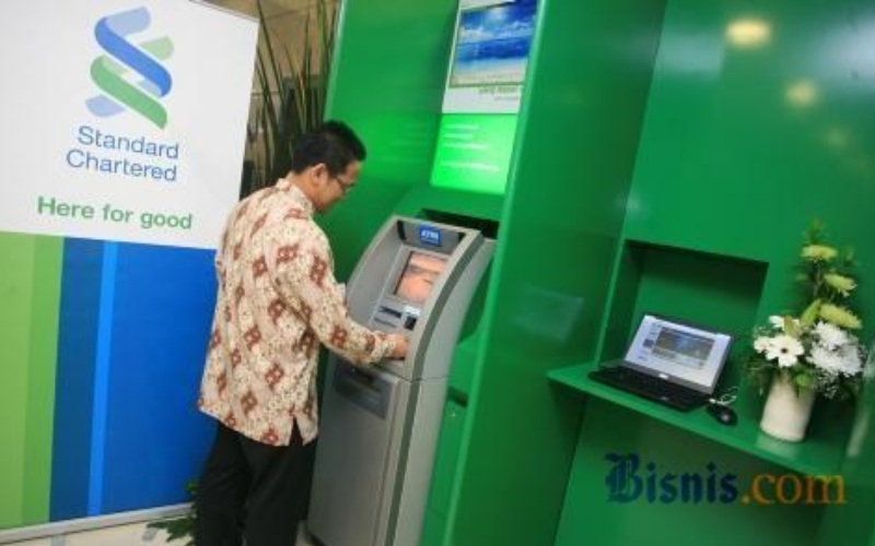 Nasabah melakukan transaksi di salah satu mesin ATM Standard Chartered Bank. - JIBI
