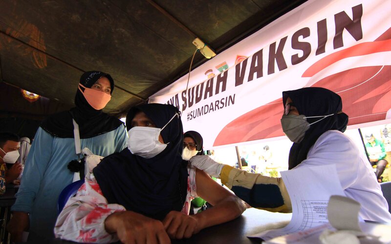 Salah seorang warga tengah disuntik vaksin dalam kegiatan Gebyar Vaksin Sumdarsin yang digelar di GOR Agus Salim Padang, Sumatra Barat, Sabtu (30/10/2021). - Bisnis/Noli Hendra