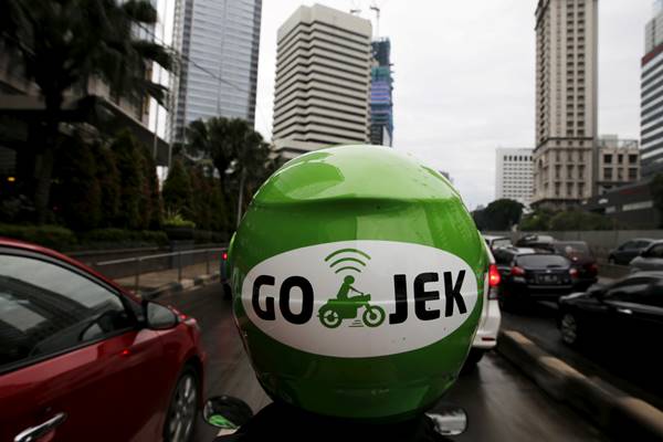 Pengemudi Gojek melintas di kawasan bisnis di Jakarta. - Reuters