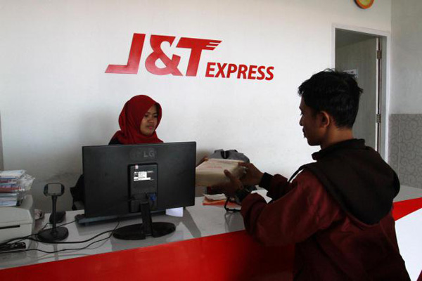Pelanggan mengirim barang melalui J&T di Makassar, Sulawesi Selatan, Selasa (22/5/2018). J&T Express memperbarui tampilan visual dan sejumlah fitur pada aplikasi yang juga mengangkat fitur order dan pelacakan sebagai menu utama. - Bisnis/Paulus Tandi Bone
