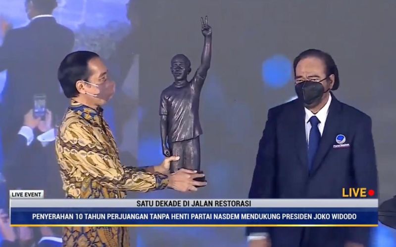 Presiden Joko Widodo menerima patung dari Ketua Umum Partai Nasdem, Surya Paloh, yang merupakan simbol 10 tahun dukungan Nasdem tanpa henti kepada Jokowi di acara HUT ke/10 Partai Nasdem di Jakarta, Kamis, 11 November 2021 / Youtube Nasdem TV