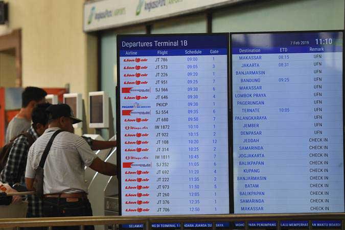 Calon penumpang mencetak tiket di samping layar informasi penerbangan di terminal keberangkatan domestik 1B Bandara Internasional Juanda Surabaya, Sidoarjo, Jawa Timur, Kamis (7/2/2019). Bandara tersebut ditutup sementara akibat rusaknya landasan pacu. - ANTARA/Zabur Karuru