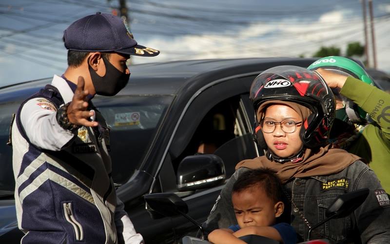 Petugas memberhentikan pengendara yang tidak memakai masker penyekatan di perbatasan Makassar-Gowa, Makassar, Sulawesi Selatan, Minggu (29/8/2021). Penyekatan tersebut untuk membatasi mobilitas masyarakat serta merazia pengendara yang tidak memakai masker saat penerapan Pemberlakuan Pembatasan Kegiatan Masyarakat (PPKM) level empat yang diperpanjang hingga 6 September 2021 sebagai upaya penanganan Covid-19. ANTARA FOTO - Arnas Padda