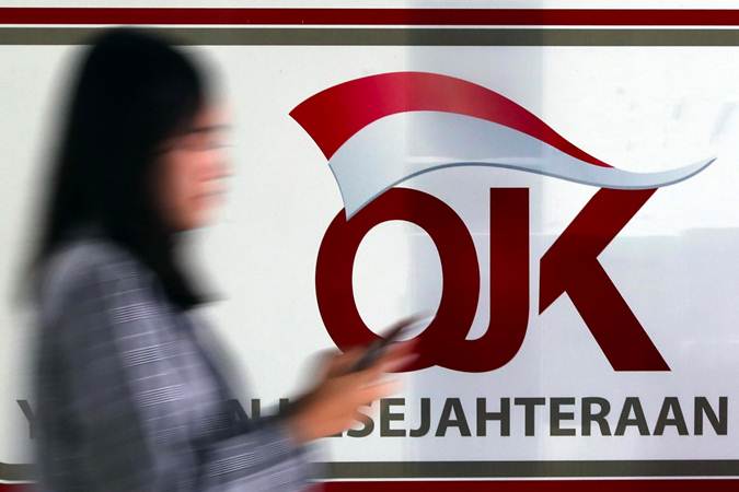 Karyawan melintas di dekat logo Otoritas Jasa Keuangan (OJK) di Jakarta, Senin (13/5/2019). - Bisnis/Abdullah Azzam