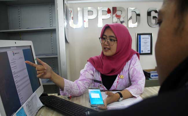Karyawan melayani warga yang berkunjung ke kantor Badan Pajak dan Retribusi Daerah, Jakarta, Rabu (15/8/2019). Bisnis - Triawanda Tirta Aditya