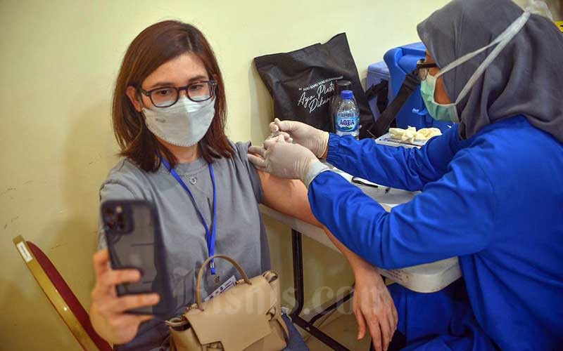 Tenaga kesehatan menyuntikan vaksin Covid-19 kepada warga DKI Jakarta berusia 18 tahun ke atas di GOR Pangadegan, Jakarta Selatan, Kamis (10/6/2021) - Bisnis/Abdullah Azzam 