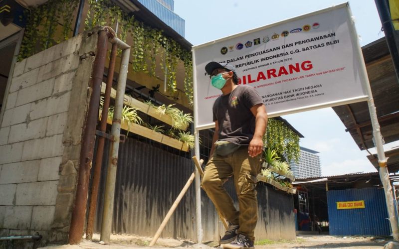 Warga melintas di dekat plang pengaman yang di pasang satgas untuk menguasai aset tanah eks BLBI di Karet Tengsin. Satuan Tugas (Satgas) BLBI telah menyita tanah seluas 26.928,9 m2 milik eks debitur Bantuan Likuiditas Bank Indonesia (BLBI) PT Sinar Bonana Jaya eks Bank Yakin Makmur (YAMA) di Karet Tengsin, Jakarta Pusat. Penyitaan itu adalah salah satu upaya Satgas BLBI untuk mengamankan aset-aset eks debitur maupun obligor BLBI supaya bisa dikelola secara optimal. - BISNIS/Suselo Jati