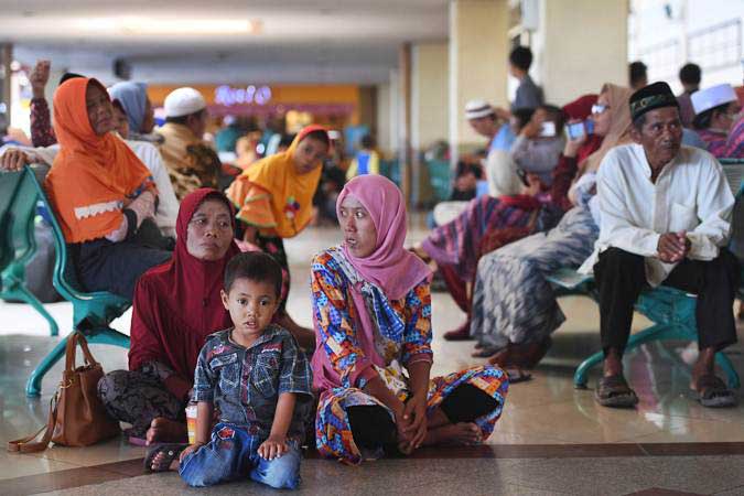 Calon penumpang duduk di lantai terminal keberangkatan domestik 1A Bandara Internasional Juanda Surabaya, Sidoarjo, Jawa Timur, Kamis (7/2/2019). - Antara/Zabur Karuru