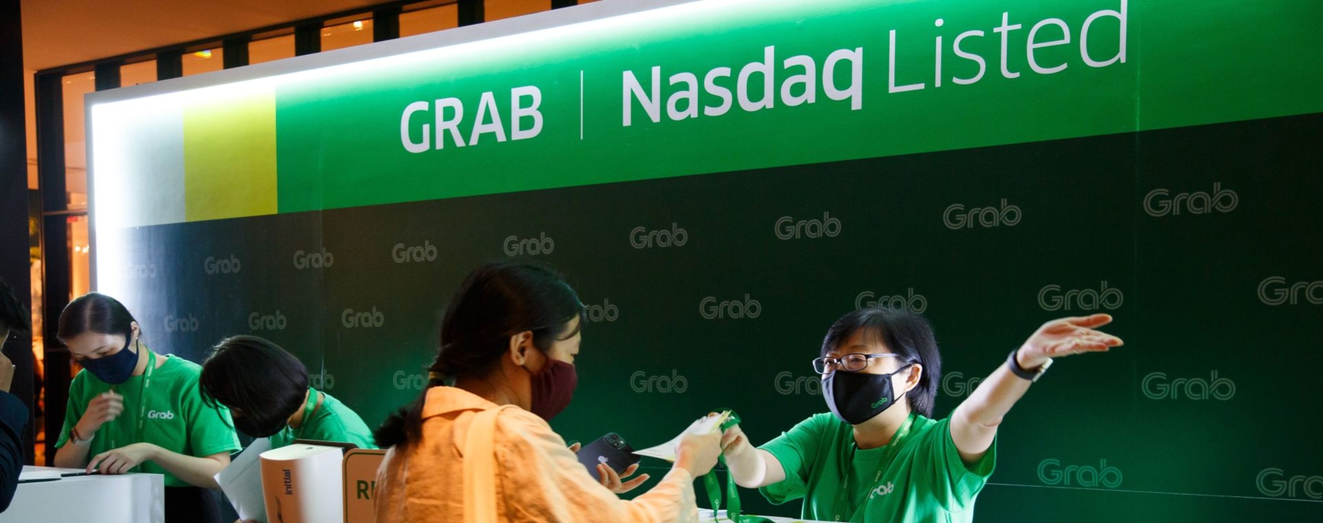 Seorang karyawan Grab mengarahkan tamu ke upacara membunyikan lonceng saat Grab mulai perdagangan perdana di Nasdaq.  - Bloomberg