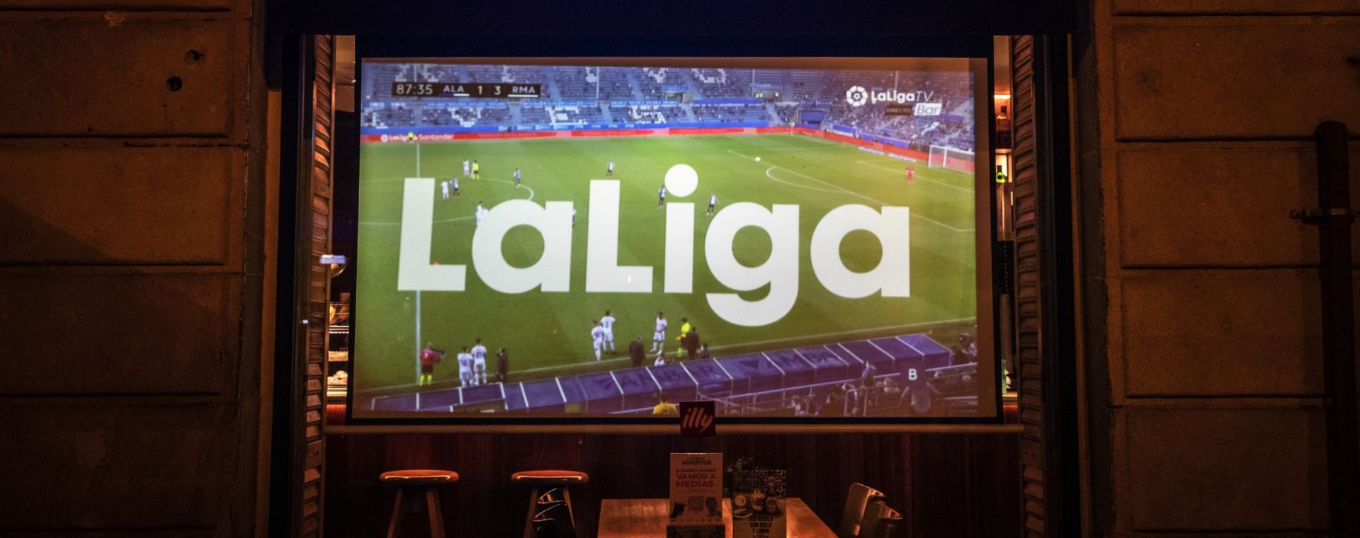Pertandingan La Liga antara FC Barcelona dan Real Sociedad di televisi di sebuah bar di Barcelona, Spanyol, pada Minggu 15 Agustus 2021.  - Bloomberg
