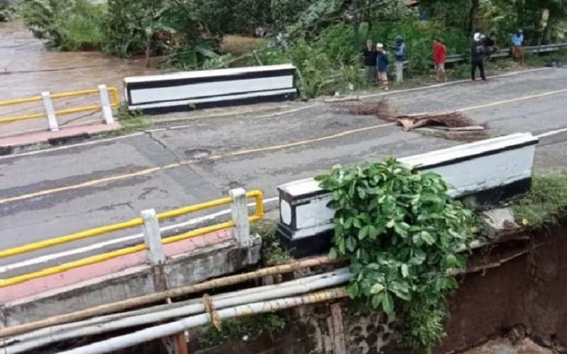 Kondisi jembatan penghubung Kota Mataram ke objek wisata Senggigi, Lombok Barat, Nusa Tenggara Barat pagi nyaris ambruk setelah diterjang banjir bandang di Sungai Meninting sejak Senin(6/12 - 2021) pagi. 