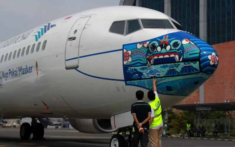 rnrnDokumentasi. Pekerja melakukan pengecekan akhir livery masker pesawat yang terpilih sebagai pemenang, sebelum peluncuran pesawat Garuda Indonesia Boing 737-800 NG bercorak khusus yang menampilkan visual masker bertema 