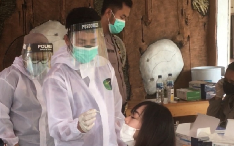 Seorang petugas memasukkan alat tes cepat (rapid test) antigen ke dalam hidung peserta rapid test antigen di Polsek Kelapa Gading, Jakarta Utara. - Antara