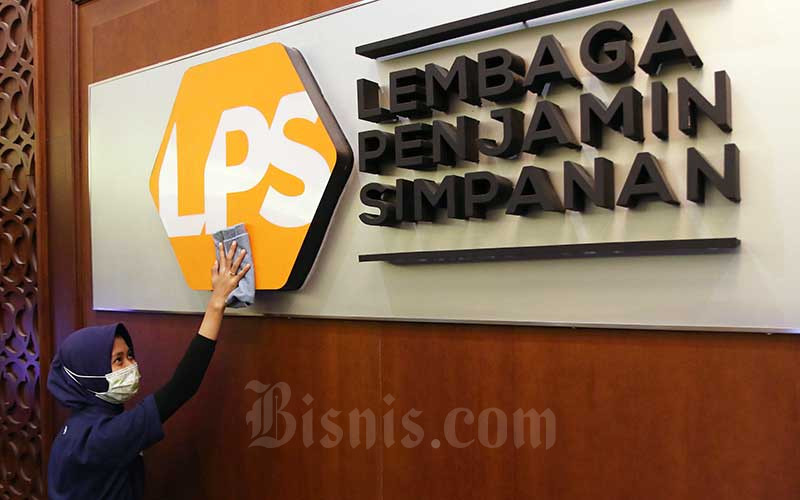 Karyawan membersihkan logo Lembaga Penjamin Simpanan (LPS) di Jakarta, Jumat (10/7/2020). Bisnis - Eusebio Chrysnamurti