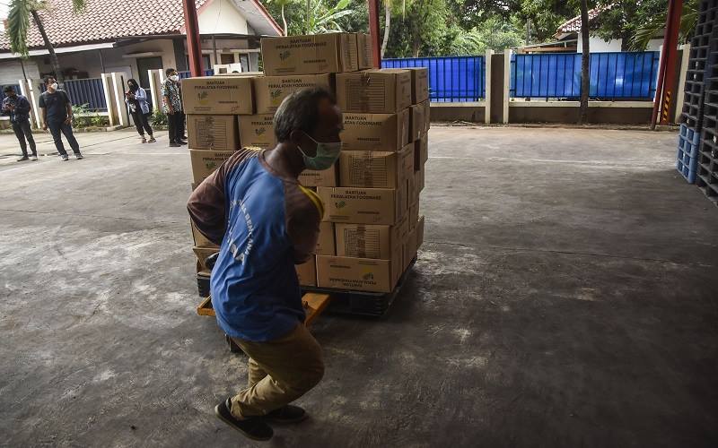 Seorang petugas menata barang di gudang logistik Gedung Departemen Sosial, Bekasi, Jawa Barat, Selasa (14/12/2021). Logistik tersebut akan didistribusikan ke lokasi bencana gempa bumi di Nusa Tenggara Timur (NTT). ANTARA FOTO -  Fakhri Hermansyah