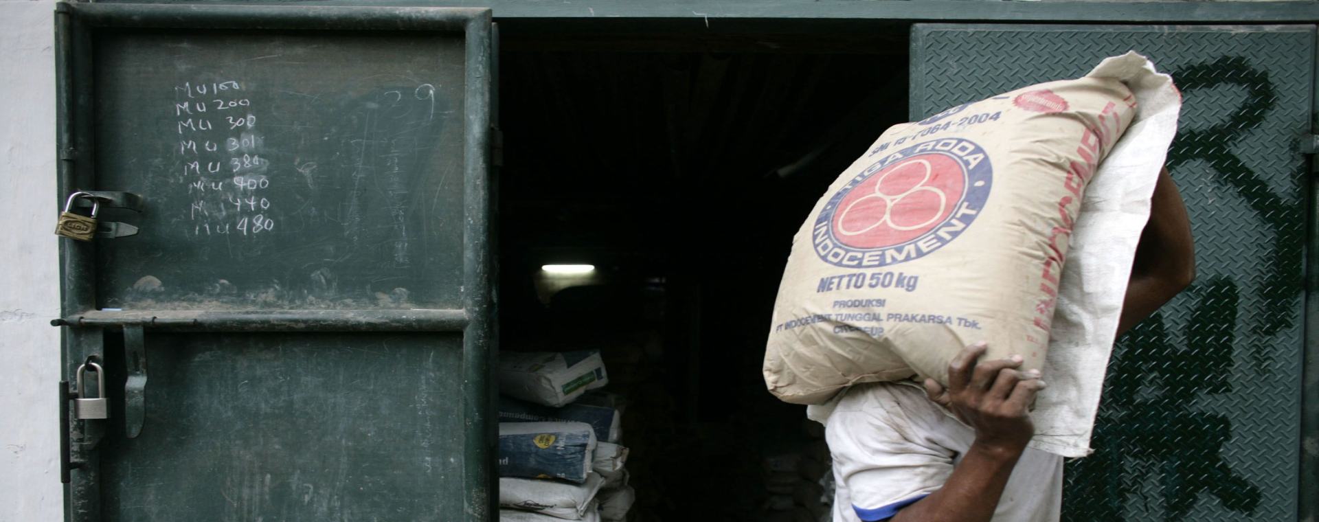 Seorang pekerja mengantarkan karung semen PT Indocement Tunggal Prakarsa ke sebuah toko di Jakarta, Indonesia, Rabu (14/4/2007). - Bloomberg/Dimas Ardian