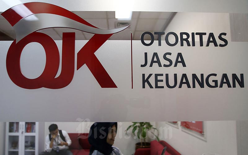 Keterangan foto: Karyawan berada di dekat logo Otoritas Jasa Keuangan di Jakarta, Jumat (17/1 - 2020). Bisnis / Abdullah Azzam
