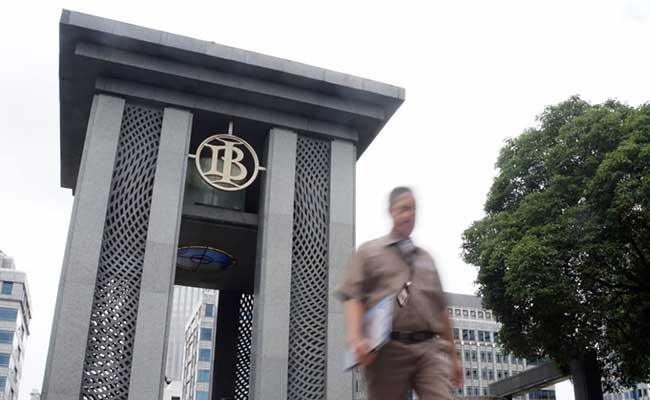 Karyawan melintas di dekat logo Bank Indonesia di Jakarta, Senin (3/2 - 2020).