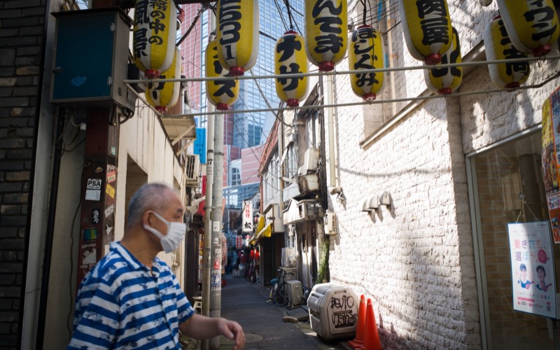 Seorang warga Jepang berdiri di sudut jalan di kota Tokyo. - Bloomberg