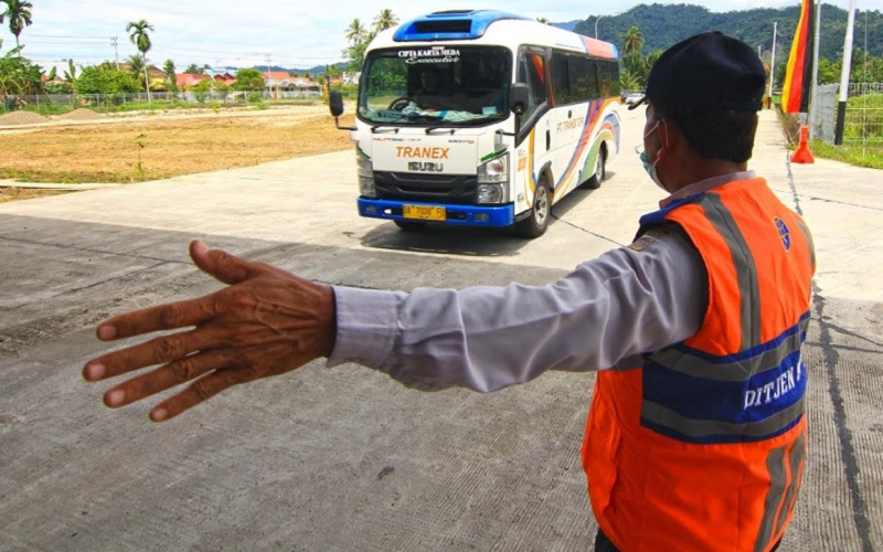 Seorang petugas tengah mengatur lalu lintas angkutan umum saat memasuki Terminal Type A, Anak Aia Padang, Sumatra Barat.  - Bisnis/Noli Hendra