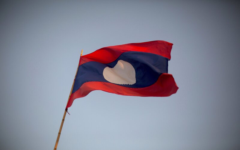 Bendera Laos yang berkibar di Luang Prabang -  Brent Lewin/Bloomberg