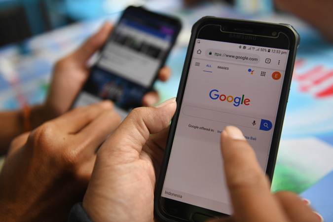 Dua orang membuka laman Google dan aplikasi Facebook melalui gawainya di Jakarta, Jumat (12/4/2019).  - ANTARA/Akbar Nugroho Gumay